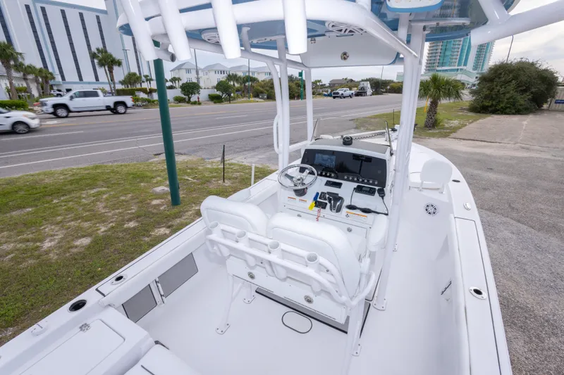 Slide: The Image of 2023 Sportsman Masters 227 Bay Boat with modern console and seating, parked near a road. - 21