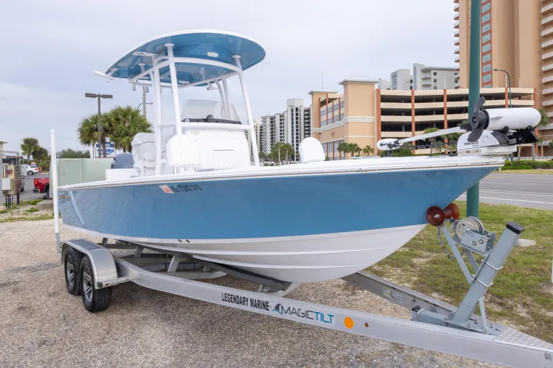 Slide: The Image of 2023 Sportsman Masters 227 Bay Boat on trailer, parked near coastal buildings. - 3