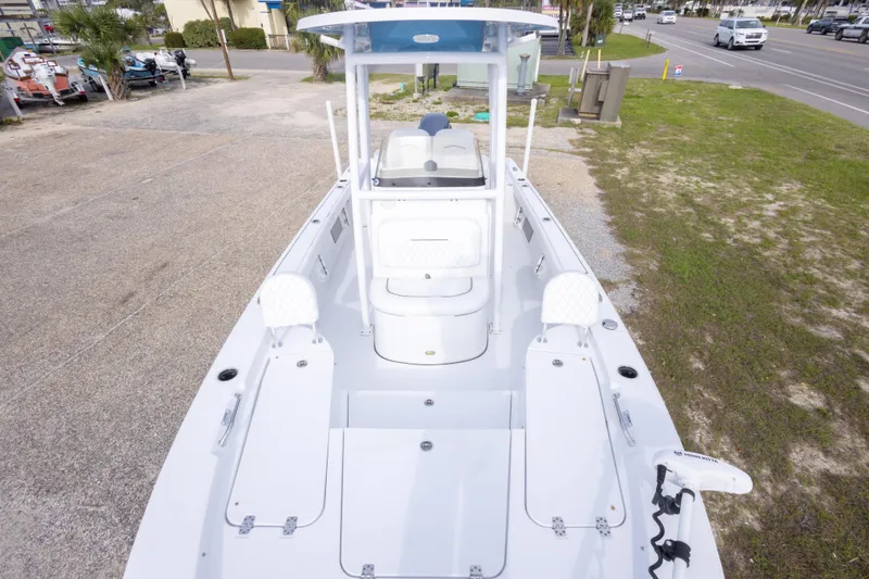 Slide: The Image of 2023 Sportsman Masters 227 Bay Boat, white interior, parked on a concrete and grass area. - 38