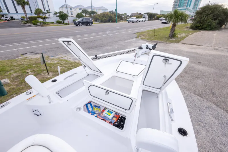 Slide: The Image of 2023 Sportsman Masters 227 Bay Boat with open storage compartments, parked near a road. - 40