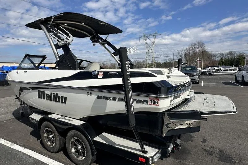 Slide: The Image of 2018 Malibu Wakesetter 21 VLX boat on trailer under clear sky. - 6