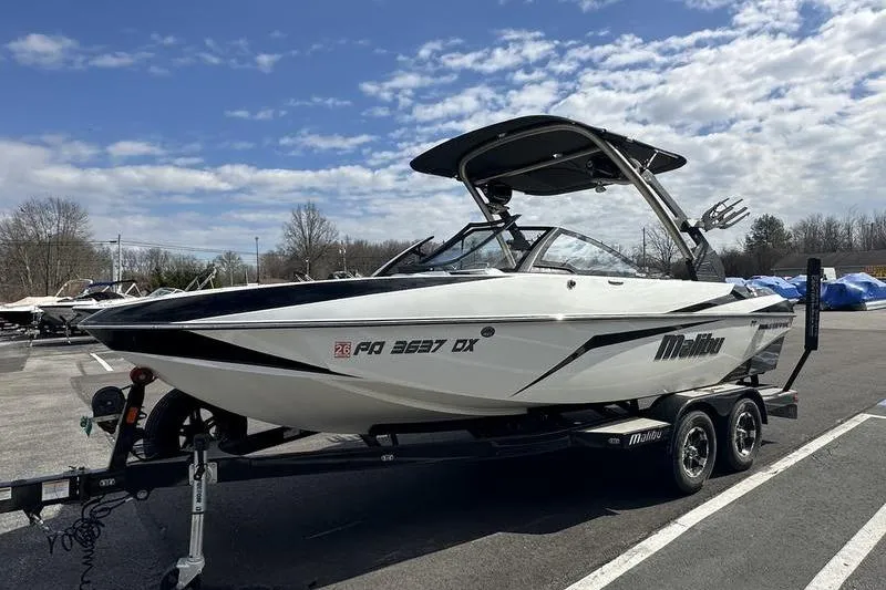 Slide: The Image of 2018 Malibu Wakesetter 21 VLX boat on trailer under a partly cloudy sky. - 7