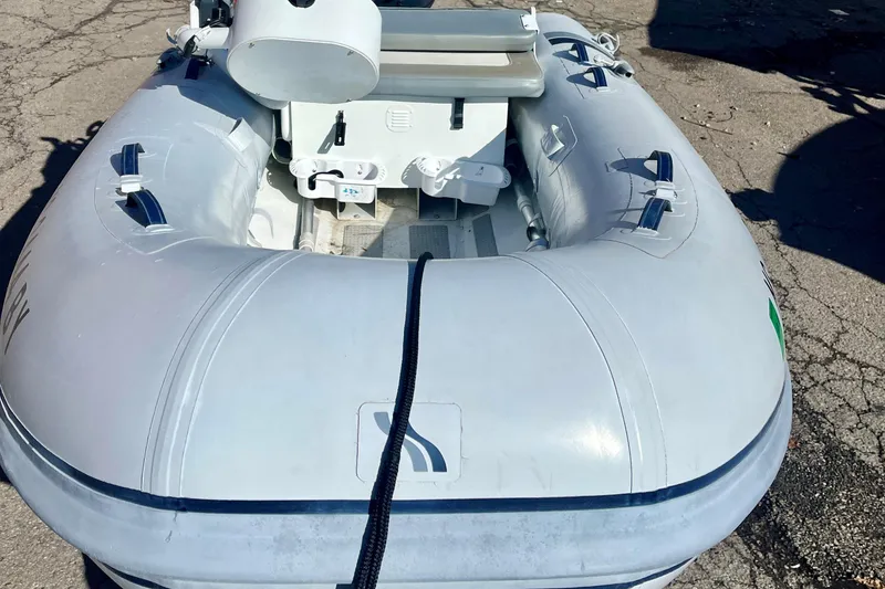 Slide: The Image of 2022 Highfield Classic 290 FT inflatable boat on pavement, showcasing interior seating and structure. - 1