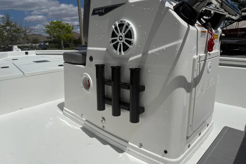 Slide: The Image of 2026 Avid 19 FSX boat interior with rod holders and speaker, under sunny skies. - 7