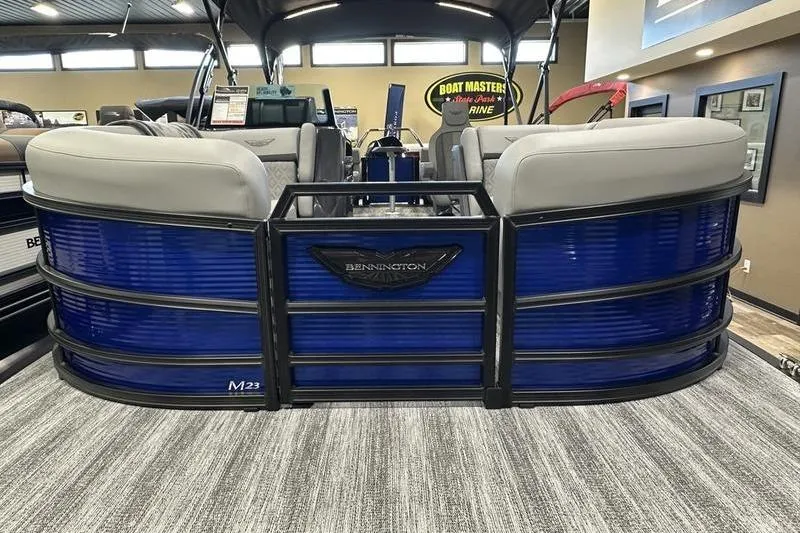 Slide: The Image of 2026 Bennington 24 M Quad Bench pontoon boat with blue exterior in showroom. - 12