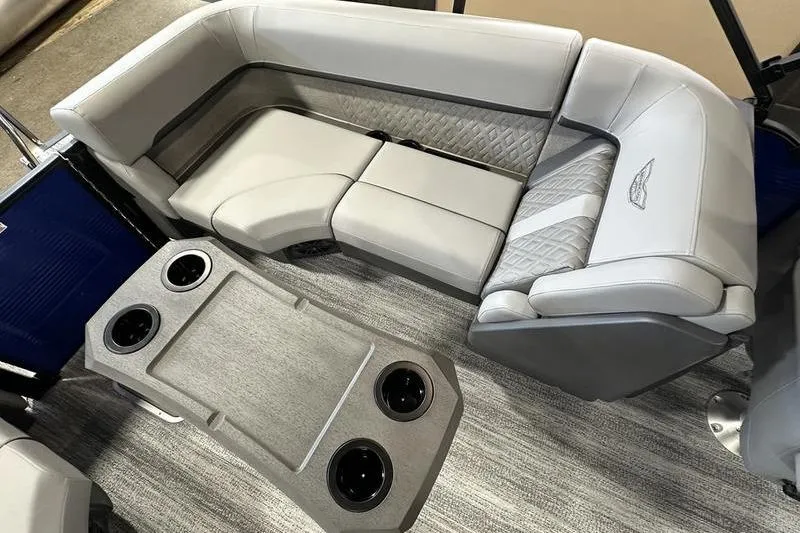 Slide: The Image of 2026 Bennington 24 M Quad Bench interior with gray seating and cup holders. - 13