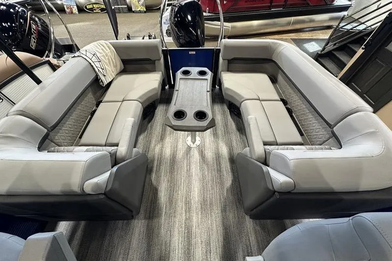 Slide: The Image of 2026 Bennington 24 M Quad Bench interior with gray seating and central table. - 19