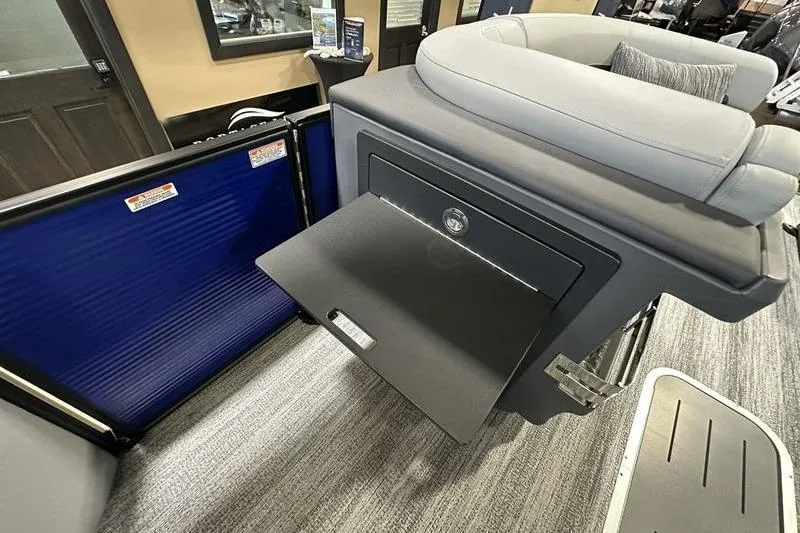 Slide: The Image of 2026 Bennington 24 M Quad Bench interior with storage compartment open. - 21