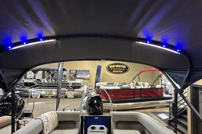 Slide: The Image of Bennington 24 M Quad Bench 2026 pontoon boat interior with canopy and showroom display. - 4