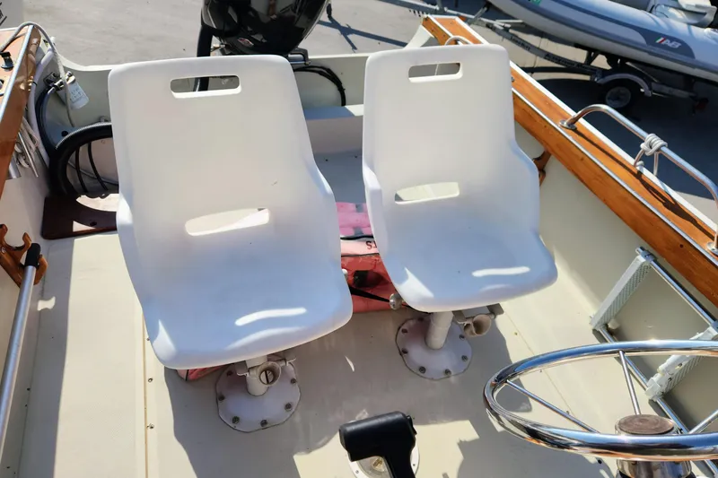 Slide: The Image of 1978 Boston Whaler Outrage 20 boat interior with white seats and steering wheel. - 16