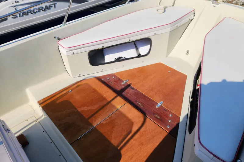 Slide: The Image of 1978 Boston Whaler Outrage 20 interior with wooden deck and cushioned seating. - 17