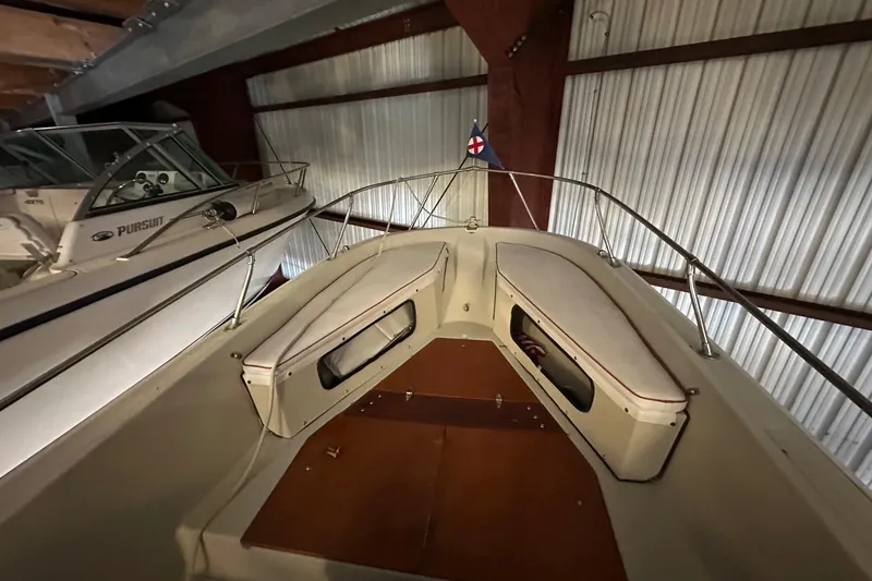 Slide: The Image of 1978 Boston Whaler Outrage 20 boat interior with cushioned seating, stored indoors. - 2