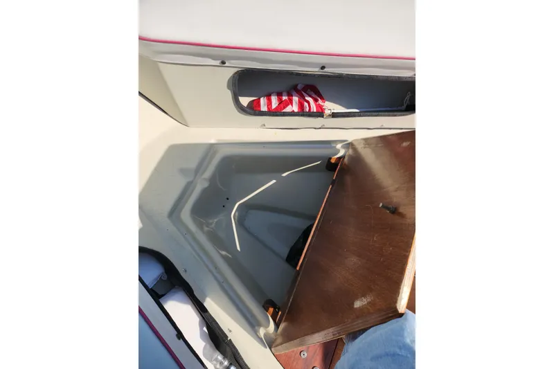Slide: The Image of 1978 Boston Whaler Outrage 20 interior storage compartment with wooden lid and striped fabric. - 21
