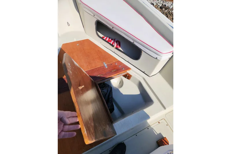 Slide: The Image of 1978 Boston Whaler Outrage 20 interior with wooden storage compartment and cushioned seating. - 22