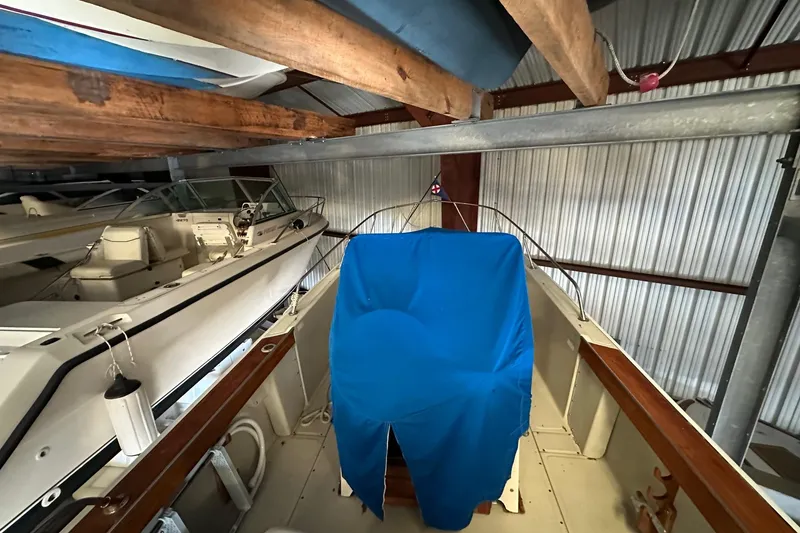 Slide: The Image of 1978 Boston Whaler Outrage 20 boat stored indoors, partially covered with blue tarp. - 4