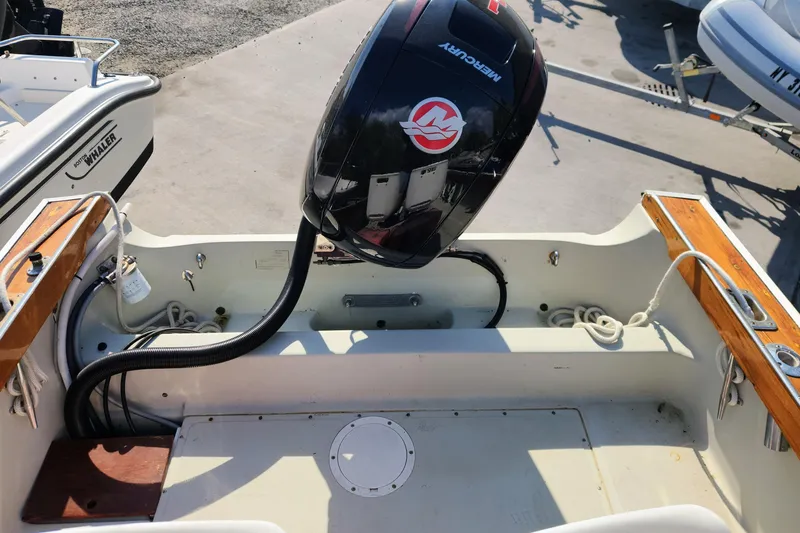 Slide: The Image of 1978 Boston Whaler Outrage 20 boat with Mercury outboard motor, docked on concrete. - 9