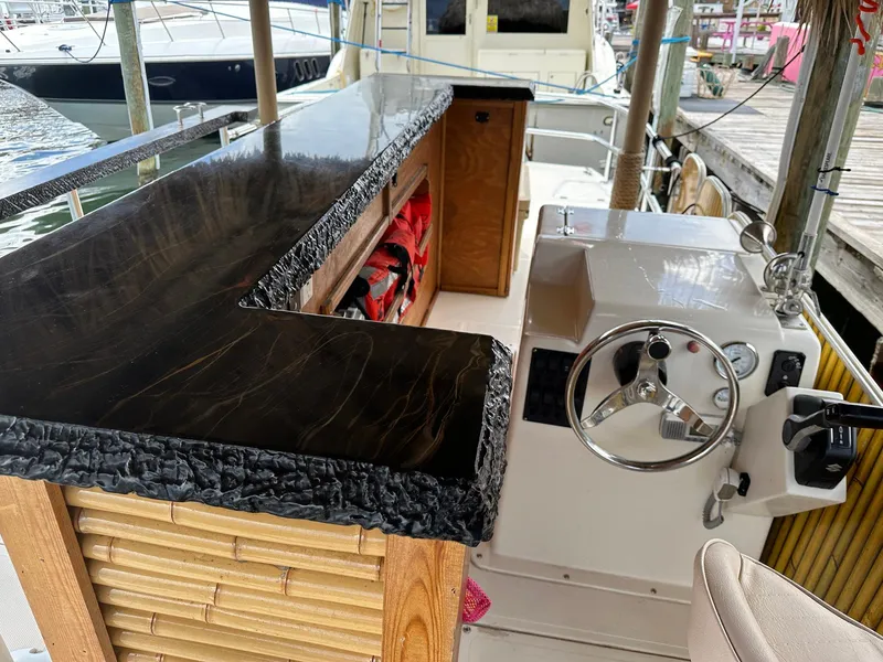 Slide: The Image of 2023 Beachcat 23 Catamaran interior with sleek black countertop and steering console. - 10