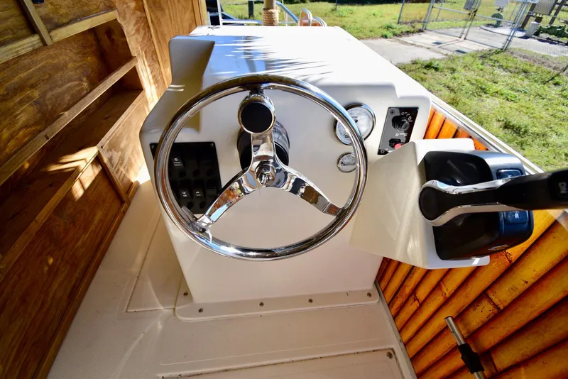 Slide: The Image of Steering console of 2023 Beachcat 23 Catamaran with chrome wheel and control panel. - 11