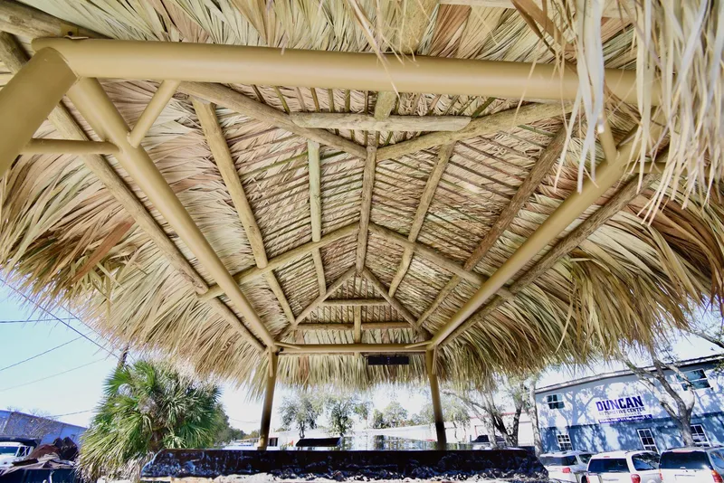 Slide: The Image of Underneath view of a thatched roof structure, showcasing wooden beams and palm leaves. - 14