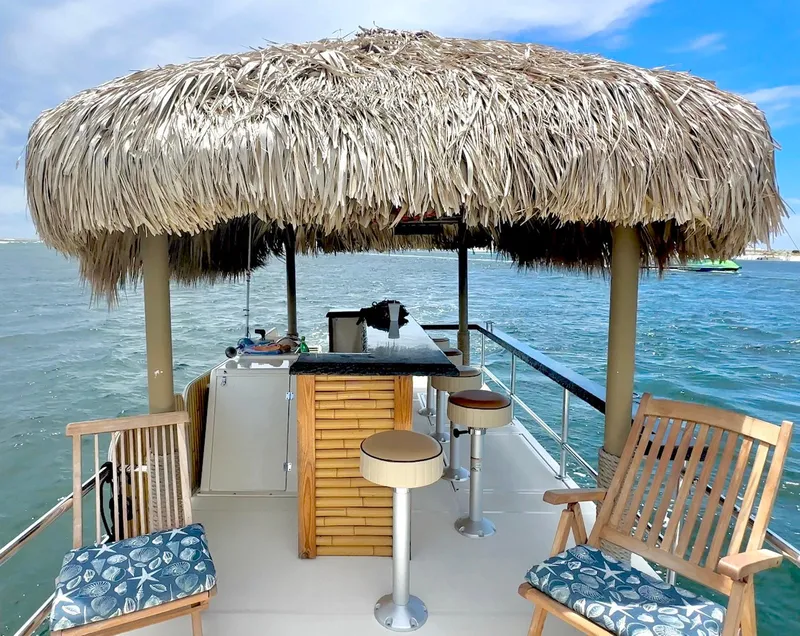 Slide: The Image of Tropical-themed 2023 Beachcat 23 Catamaran with tiki bar and seating on open water. - 8