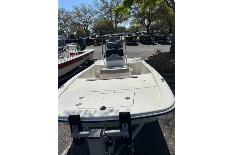 Slide: The Image of 2025 Mako Pro Skiff 13 CC boat displayed outdoors, surrounded by trees. - 1