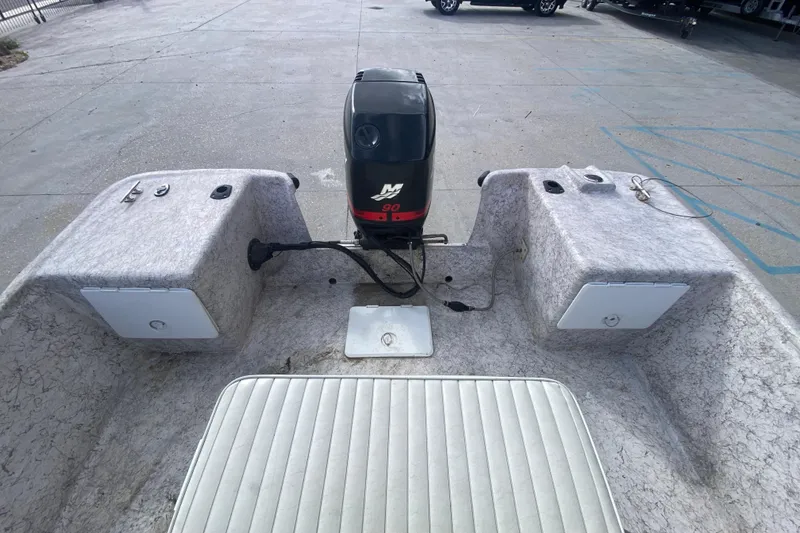 Slide: The Image of 2001 Fishmaster 17 boat interior with motor, storage compartments, and seating. - 11