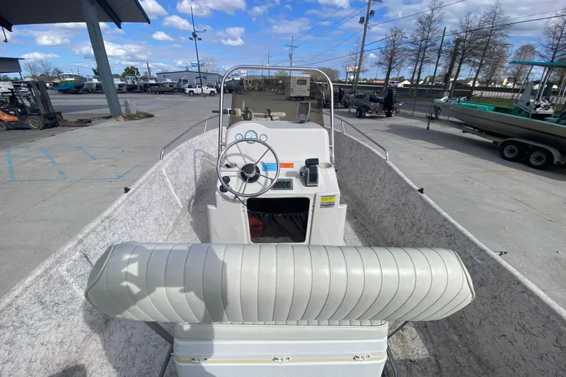 Slide: The Image of 2001 Fishmaster 17 boat interior with steering wheel and seating, parked outdoors. - 12