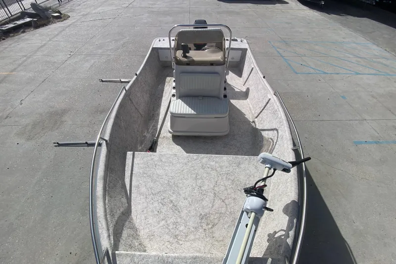 Slide: The Image of 2001 Fishmaster 17 boat with seating and trolling motor on concrete surface. - 17