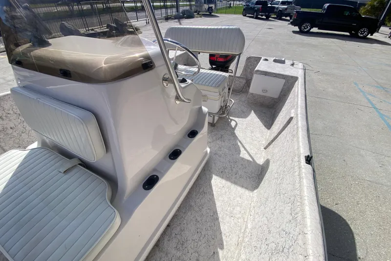 Slide: The Image of 2001 Fishmaster 17 boat interior with seating and steering console in a parking area. - 20