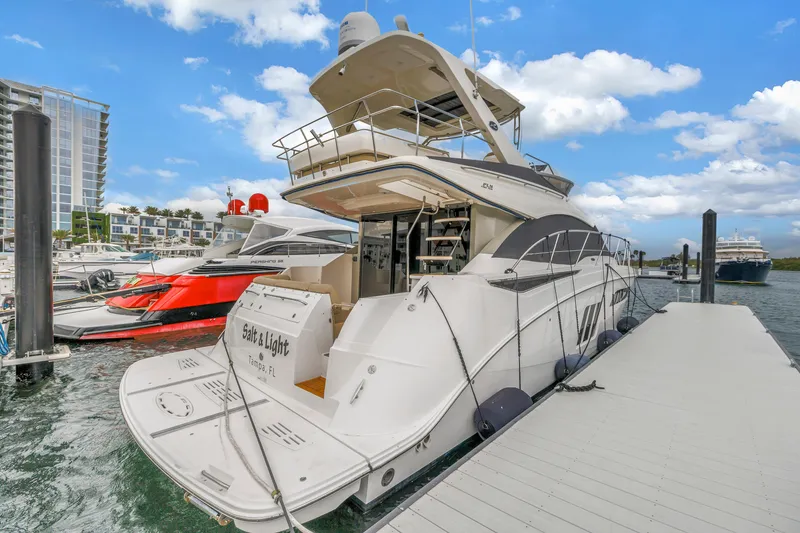 Slide: The Image of 2016 Sea Ray 510 Fly yacht docked at marina under blue sky. - 10