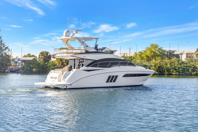 Slide: The Image of 2016 Sea Ray 510 Fly yacht cruising on a sunny day, surrounded by lush greenery. - 3