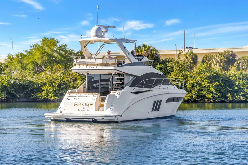 Slide: The Image of 2016 Sea Ray 510 Fly yacht cruising on a sunny day near lush greenery. - 4