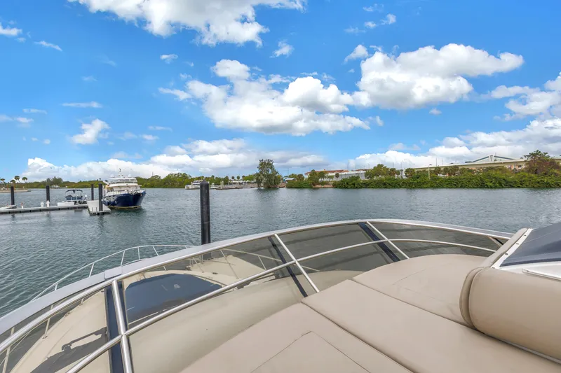 Slide: The Image of 2016 Sea Ray 510 Fly yacht docked in a serene marina under a blue sky. - 40