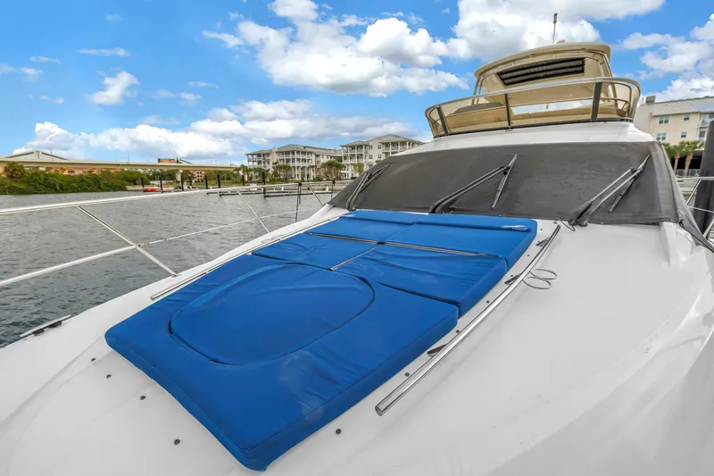 Slide: The Image of 2016 Sea Ray 510 Fly yacht with blue sun pads on deck, docked by waterfront. - 50
