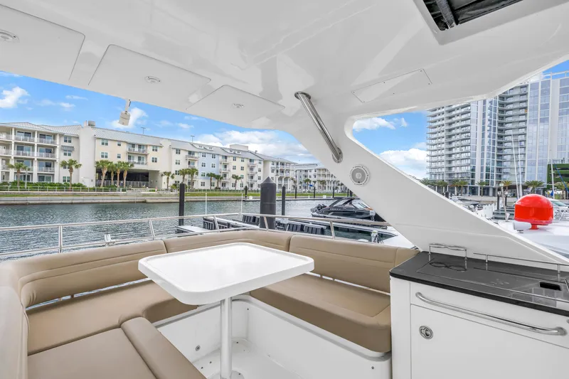 Slide: The Image of Outdoor seating area on a 2016 Sea Ray 510 Fly yacht, docked near waterfront buildings. - 35