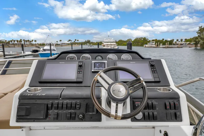 Slide: The Image of Helm of 2016 Sea Ray 510 Fly yacht with navigation screens and steering wheel. - 42