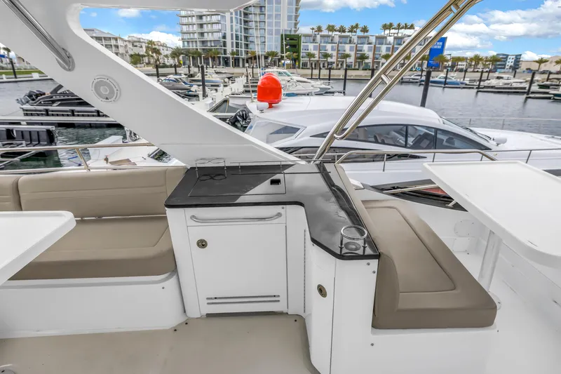 Slide: The Image of Flybridge seating area on a 2016 Sea Ray 510 Fly yacht, docked at a marina. - 43