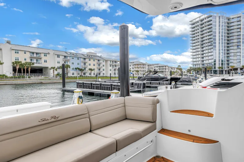 Slide: The Image of 2016 Sea Ray 510 Fly yacht docked at marina with modern buildings in background. - 44