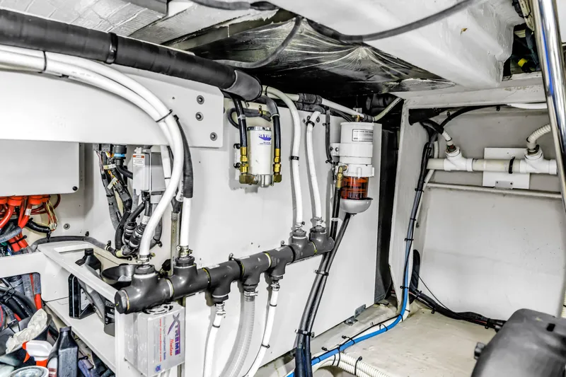 Slide: The Image of Engine room of 2016 Sea Ray 510 Fly yacht, showcasing complex piping and wiring systems. - 59