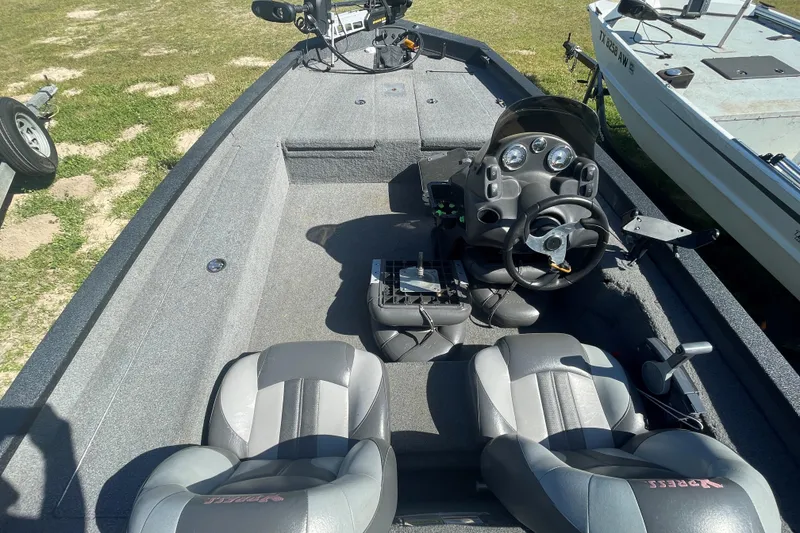 Slide: The Image of 2013 Xpress H18 boat interior with steering console and seating on grassy area. - 3