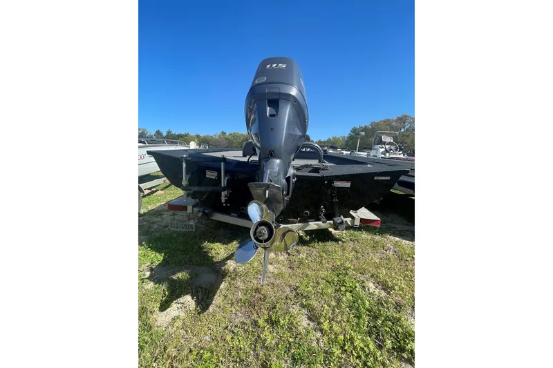 Slide: The Image of 2013 Xpress H18 boat with outboard motor on a trailer, parked on grass. - 4