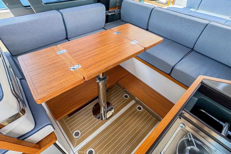 Slide: The Image of Interior of 2025 Aiata Wayfinder 38 Cabin with wooden table and gray seating. - 26
