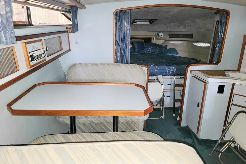 Slide: The Image of Interior of 1987 Sea Ray 340 Express Cruiser with dining area and sleeping quarters. - 11