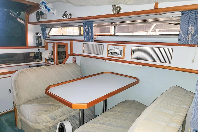 Slide: The Image of Interior of 1987 Sea Ray 340 Express Cruiser with dining area and vintage decor. - 12
