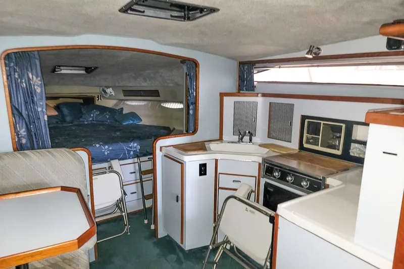 Slide: The Image of Interior of 1987 Sea Ray 340 Express Cruiser with kitchenette and sleeping area. - 13