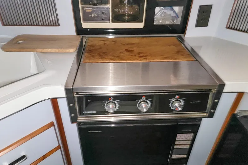 Slide: The Image of 1987 Sea Ray 340 Express Cruiser kitchen with stove, cutting board, and appliances. - 15