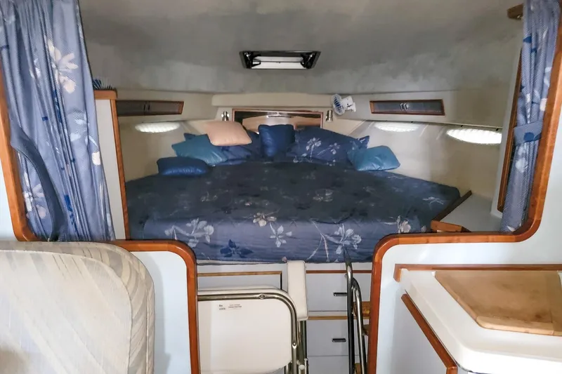 Slide: The Image of 1987 Sea Ray 340 Express Cruiser cabin with floral bedding and cozy interior. - 16