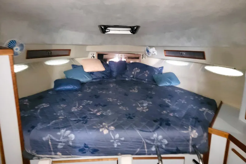 Slide: The Image of 1987 Sea Ray 340 Express Cruiser cabin with floral bedding and cozy interior. - 17