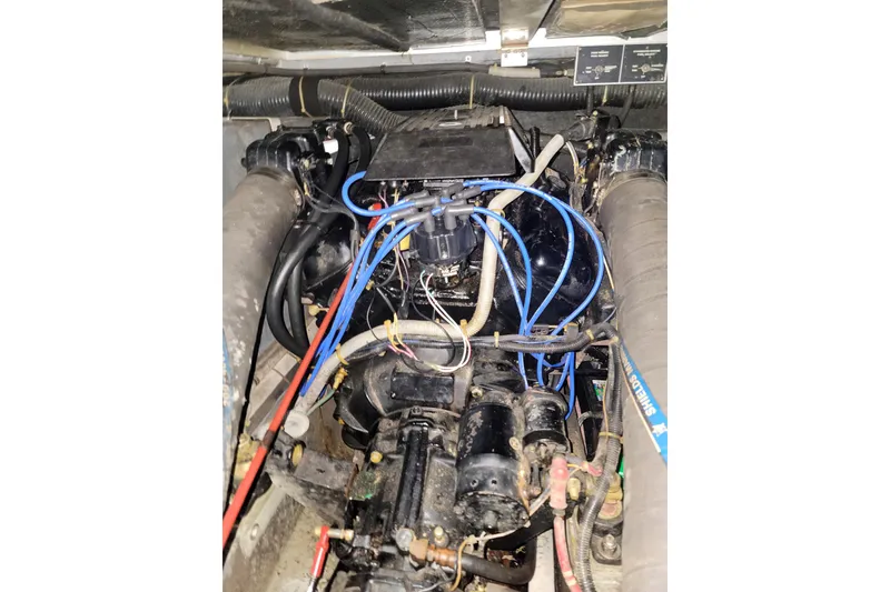 Slide: The Image of Engine compartment of a 1987 Sea Ray 340 Express Cruiser with visible wiring and components. - 19