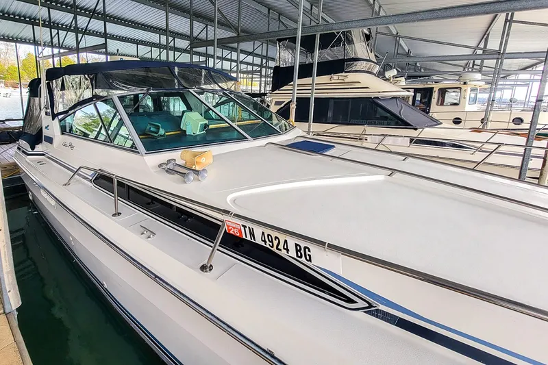 Slide: The Image of 1987 Sea Ray 340 Express Cruiser docked in a covered marina. - 2